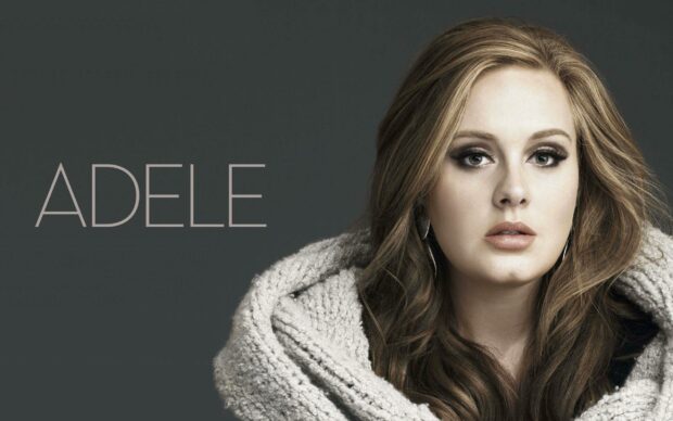 A close up portrait of Adele wearing a warm knitted shawl against a gray background, 2K Desktop Wallpaper