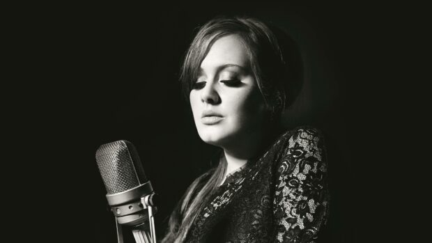 Adele is performing passionately in front of a microphone in a black and white setting, 4K Desktop Wallpaper