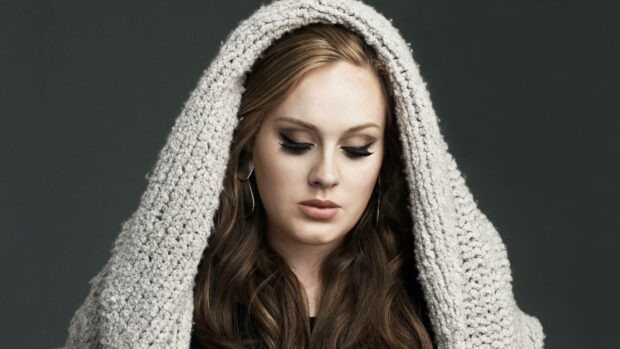 Adele looks down wearing a textured knitted shawl over her head and hoop earrings, HD Desktop Wallpaper
