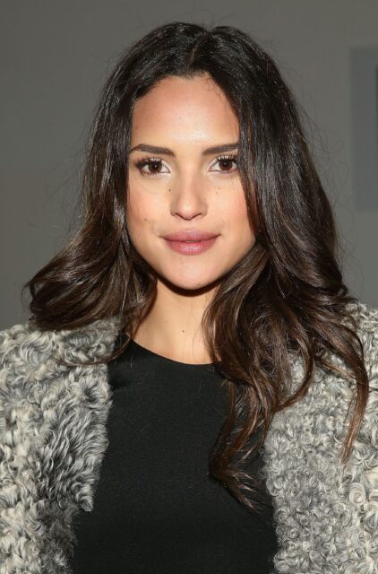 Adria Arjona close up portrait with curly hair and textured coat wallpaper