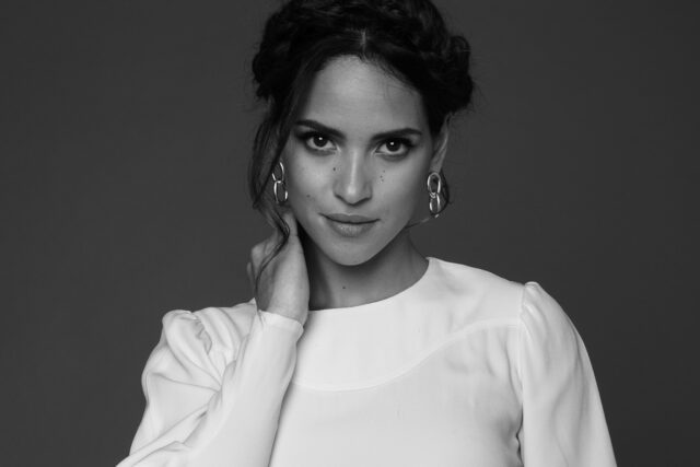 Adria Arjona elegant black and white portrait wallpaper with white blouse and silver earrings
