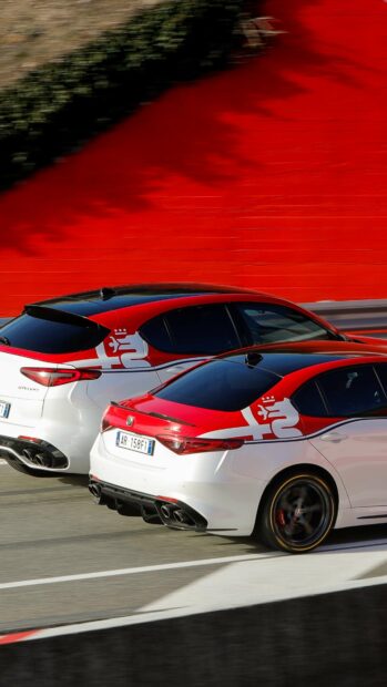 Two Alfa Romeo cars race on a track with a bright red wall in the background, 4K Mobile Wallpaper