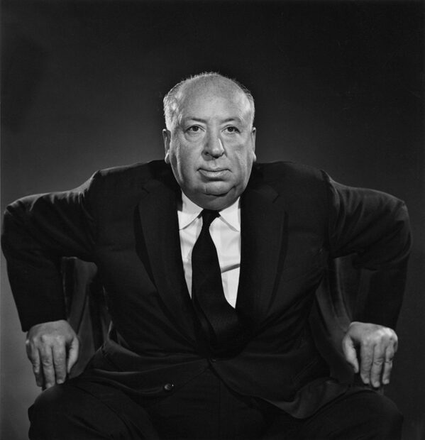 Alfred Hitchcock sitting in a chair with his hands resting on the armrests, HD Desktop Wallpaper