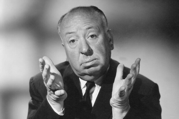 Alfred Hitchcock gestures thoughtfully in a black and white portrait, HD Desktop Wallpaper