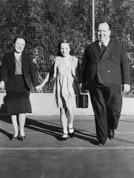 Alfred Hitchcock with a woman and a girl walking hand in hand outside on a sunny day, HD Phone Wallpaper
