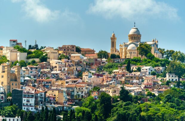 The Algeria Wallpapers show a vibrant hillside city with historic buildings and lush greenery under a clear sky, HD Desktop Wallpaper