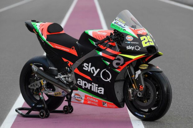 Aprilia Wallpapers show a detailed view of a racing motorcycle with sponsor logos parked on a race track, HD Desktop Wallpaper