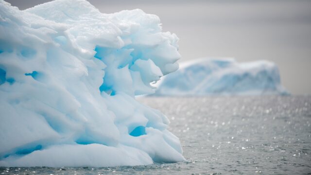 Arctic Ocean Icebergs Floating On Calm Water In Overcast Weather Wallpaper