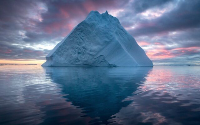 Arctic Ocean Wallpaper With Massive Iceberg And Calm Reflective Water At Sunset
