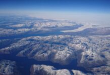 Arctic Ocean Aerial View With Snow Covered Islands And Deep Blue Waters Wallpaper