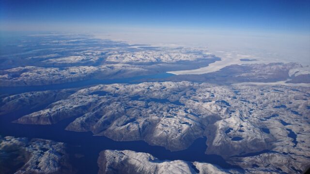 Arctic Ocean Aerial View With Snow Covered Islands And Deep Blue Waters Wallpaper