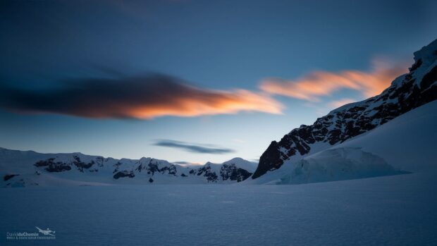 The Arctic sunset casts a warm glow on the icy mountains and snowfield, 2K Desktop Wallpaper