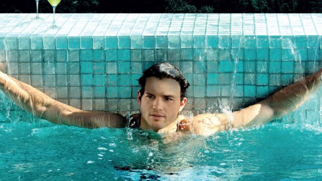 Ashton Kutcher Relaxing In Pool With Blue Tiled Background Wallpaper
