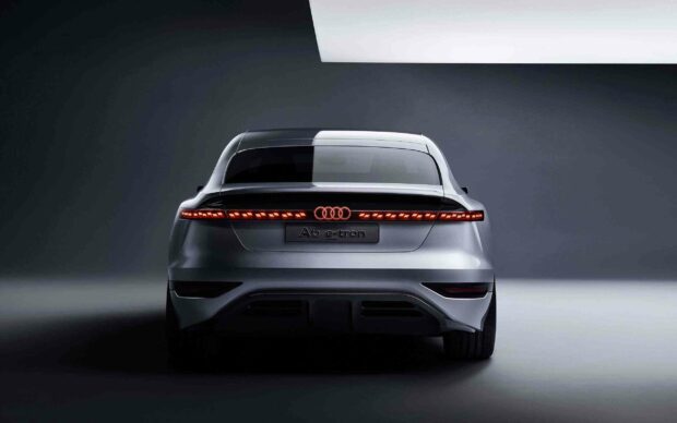 The rear view of an Audi A6 e tron features sleek LED tail lights and a modern silhouette, 2K Desktop Wallpaper