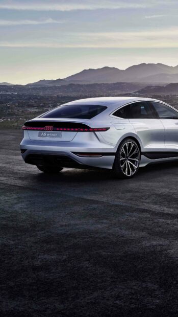 The Audi A6 is shown in a rear view with modern lighting and wheels against a mountainous background, 4K Mobile Wallpaper
