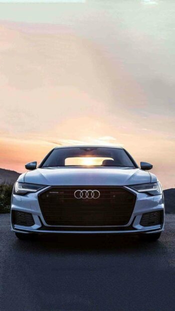 The Audi A6 is parked with the sunset sky in the background highlighting its grille and headlights, HD Phone Wallpaper