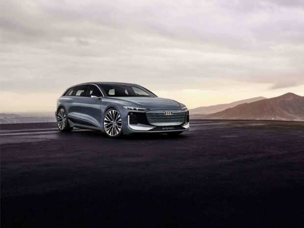A sleek Audi A6 is parked on an open dark road with mountains in the background under a cloudy sky, HD Desktop Wallpaper