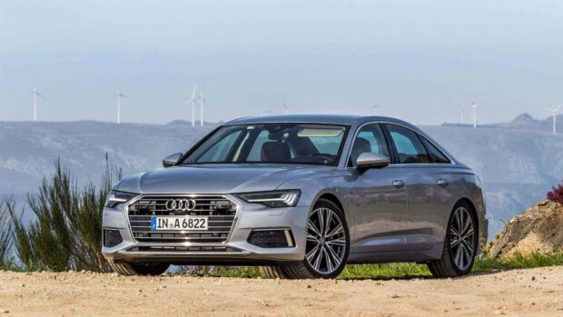 A silver Audi A6 parked on a dirt road with wind turbines and mountains in the background, HD Desktop Wallpaper