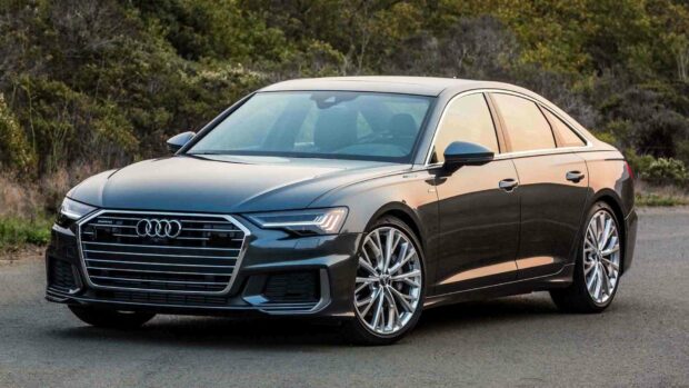 A sleek black Audi A6 is parked on a road with greenery in the background, HD Desktop Wallpaper