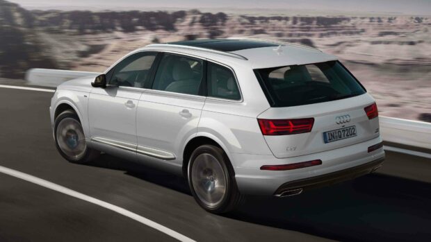 The Audi Q7 is driving along a winding road with blurred natural scenery in the background, 4K Desktop Wallpaper