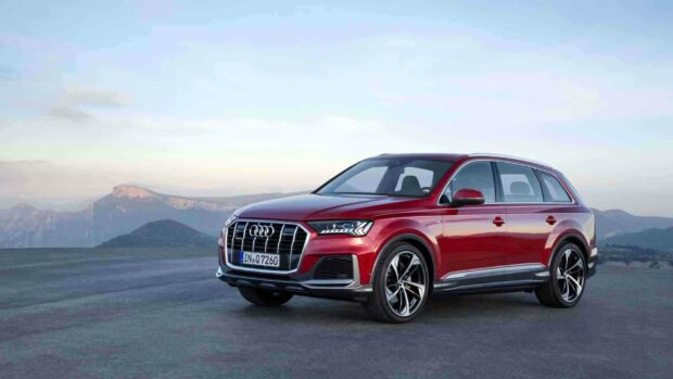 A red Audi Q7 is parked on a flat surface with mountains in the background, HD Desktop Wallpaper