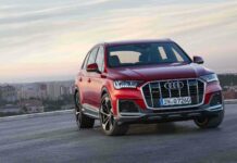 A red Audi Q7 stands on a rooftop with a cityscape in the background, HD Desktop Wallpaper