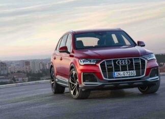 A red Audi Q7 stands on a rooftop with a cityscape in the background, HD Desktop Wallpaper