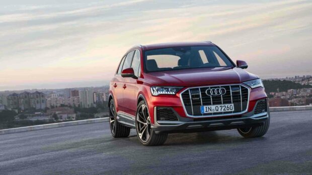 A red Audi Q7 stands on a rooftop with a cityscape in the background, HD Desktop Wallpaper