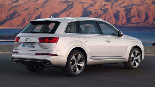 A white Audi Q7 is parked near a body of water with mountains in the background, 4K Desktop Wallpaper