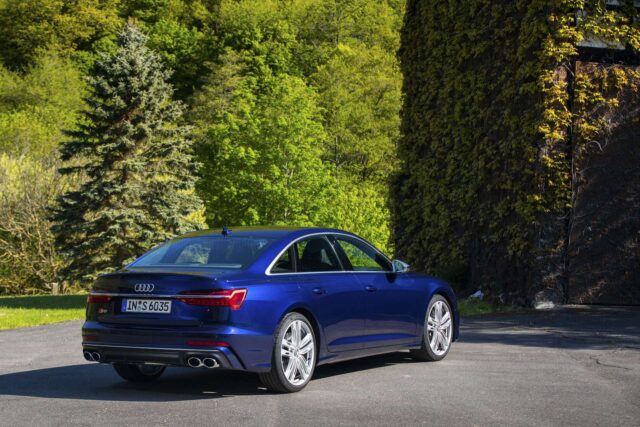 Audi S6 Blue Sedan Parked In Scenic Green Forest Background Wallpaper