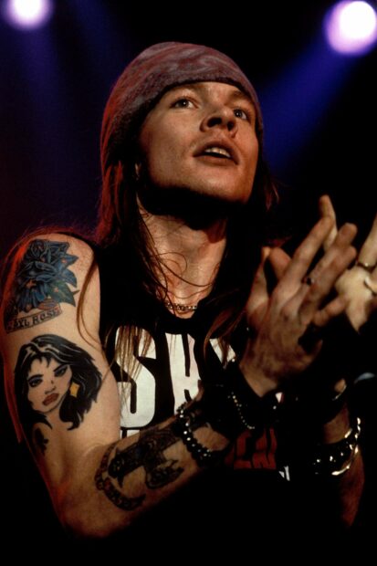 Axl Rose is passionately performing on stage showing his iconic tattoos and bandana, HD Desktop Wallpaper