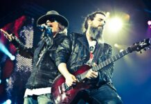 Axl Rose is singing passionately during a concert with a guitarist playing beside him, HD Desktop Wallpaper