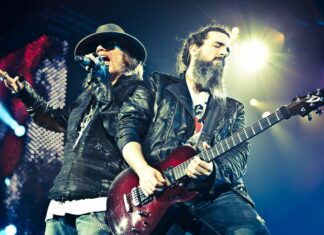 Axl Rose is singing passionately during a concert with a guitarist playing beside him, HD Desktop Wallpaper