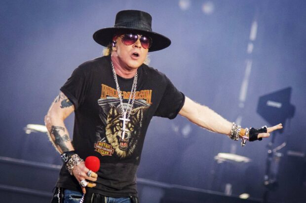 Axl Rose passionately singing during a concert performance, 2K Desktop Wallpaper