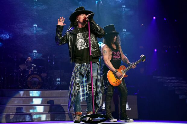 Axl Rose is performing live with a guitarist on a lit stage, 2K Desktop Wallpaper