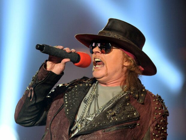 Axl Rose is passionately singing into a microphone during a live performance, HD Desktop Wallpaper