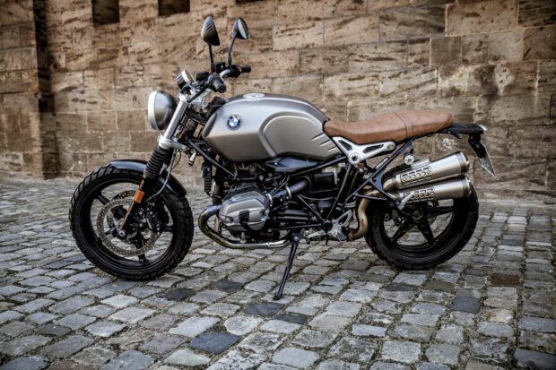 A BMW R Nine T motorcycle parked on cobblestone pavement near a stone wall, HD Desktop Wallpaper