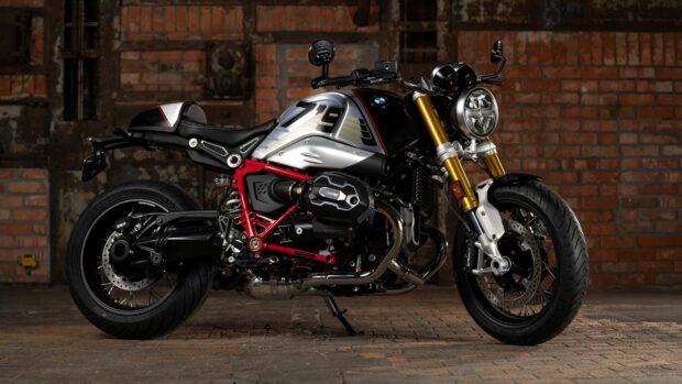 A BMW R Nine T motorcycle with a black and silver body is parked in a dimly lit brick garage, 4K Desktop Wallpaper
