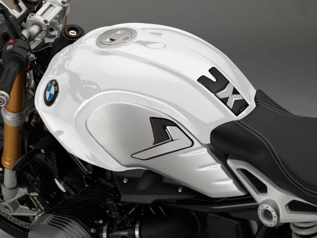 The image shows a close up of a white BMW R Nine T motorcycle fuel tank and seat, 2K Desktop Wallpaper