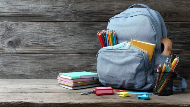Back To School Background, An Open Backpack With School Items Scattered Around On A Wooden Table