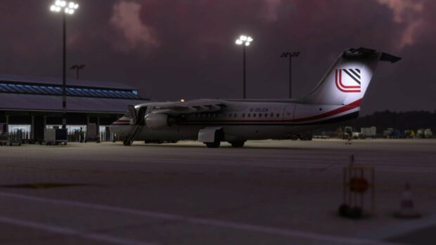 A Bae Avro airplane is parked on the tarmac under airport lights during the evening, 2K Desktop Wallpaper