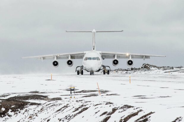 A Bae Avro airplane is stationed on a snow covered runway surrounded by a cold and cloudy environment, HD Desktop Wallpaper