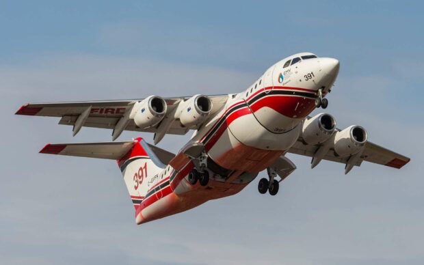 A Bae Avro airplane with red and white colors flies in a clear sky, HD Desktop Wallpaper