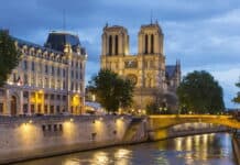 The cathedral wallpapers is illuminated with city lights under a cloudy sky, 4K Desktop Wallpaper