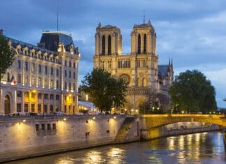 The cathedral wallpapers is illuminated with city lights under a cloudy sky, 4K Desktop Wallpaper