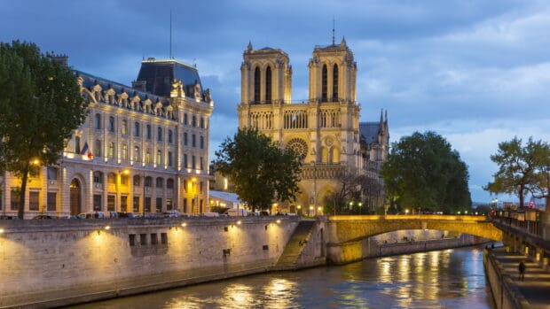The cathedral wallpapers is illuminated with city lights under a cloudy sky, 4K Desktop Wallpaper