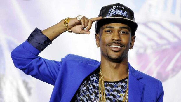 Big Sean in a blue blazer and patterned shirt smiling while adjusting his Detroit Lions cap, HD Desktop Wallpaper