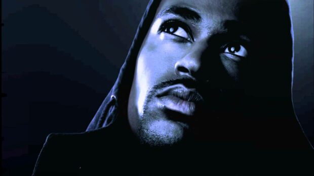 A close up of Big Sean gazing upward with a dark hood against a deep blue background, HD Desktop Wallpaper