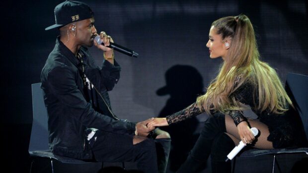 Big Sean is holding a microphone and holding hands with a female singer during a live concert, HD Desktop Wallpaper