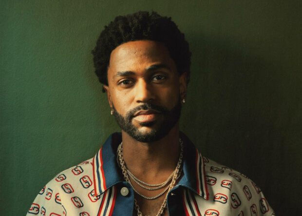 A close up portrait of Big Sean wearing a patterned jacket and layered chains against a dark green background, HD Desktop Wallpaper